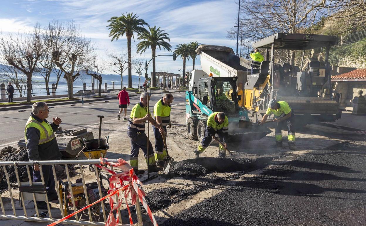 Los operarios extienden el asfalto al final de la Cuesta de las Viudas, con Reina Victoria. 