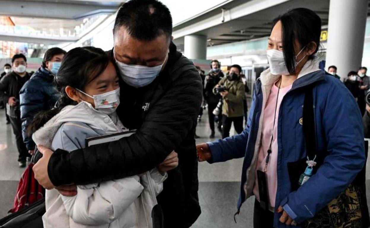 Una familia se abraza al encontrarse en el aeropuerto de Pekín, tras tres años de 'cerrojazo' por la pandemia en China. 