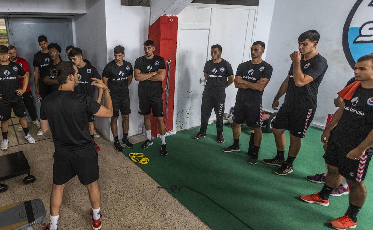 El preparador físico Sergio Carrascón da indicaciones a los jugadores del Sinfín.