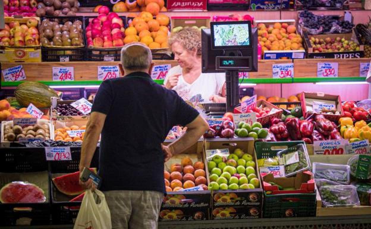 Un hombre observa la oferta de productos de una frutería. 