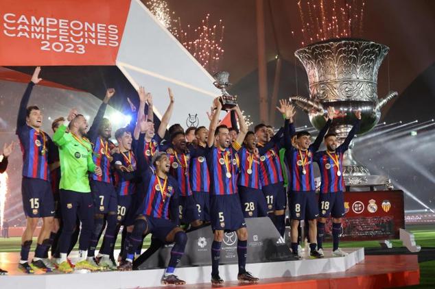 Busquets eleva al cielo el trofeo de la Supercopa ante el resto de jugadores del Barça.