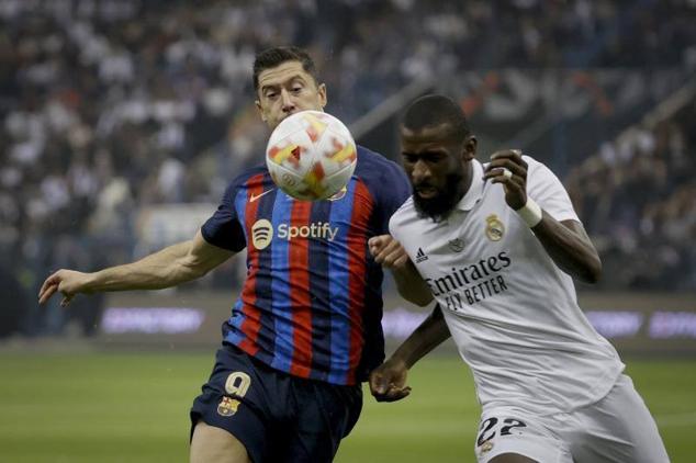 Lewandowski y Rüdiger disputan un balón.