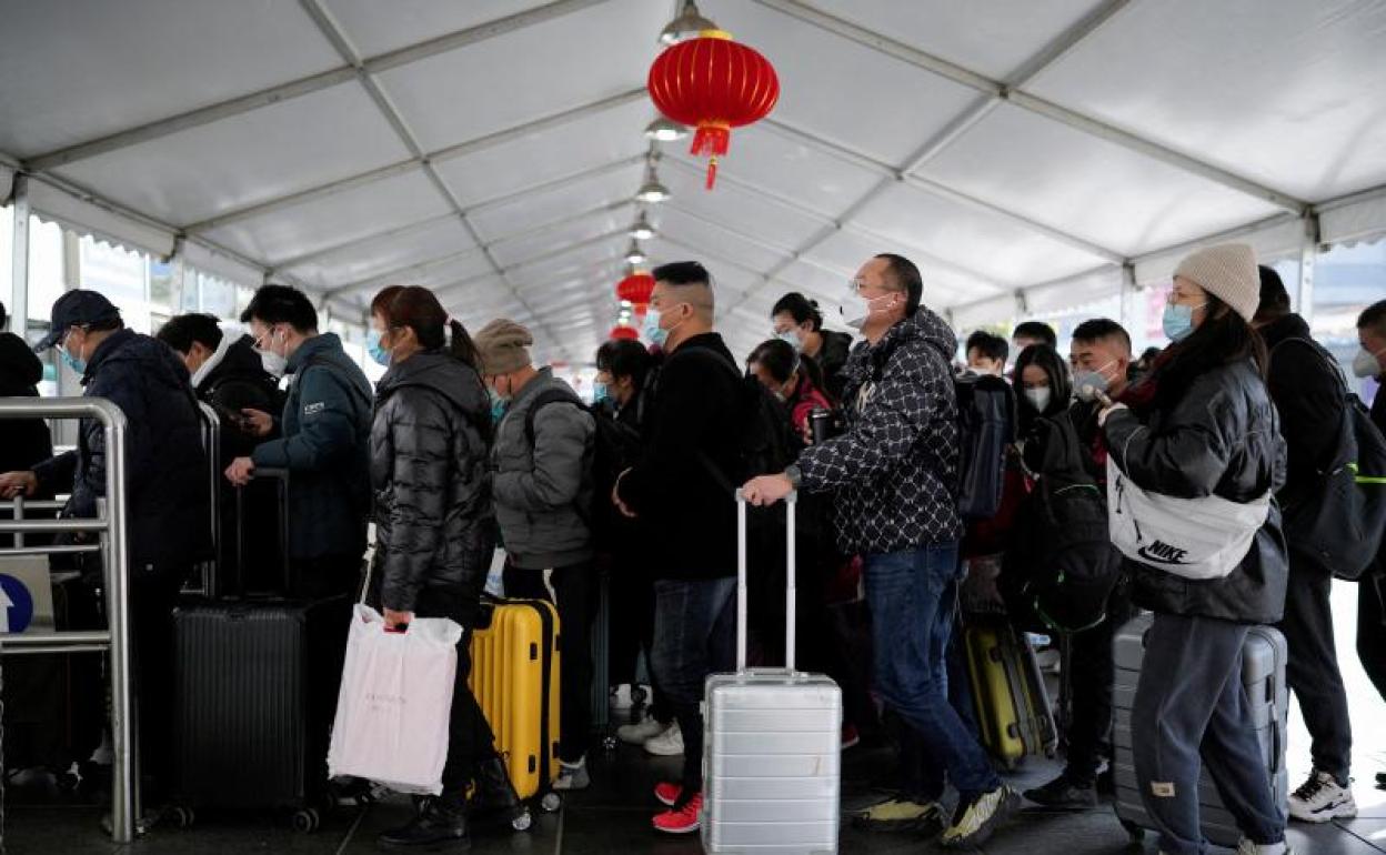 La gente camina con su equipaje en una estación de tren durante la fiebre anual del Festival de Primavera antes del Año Nuevo Lunar chino. 