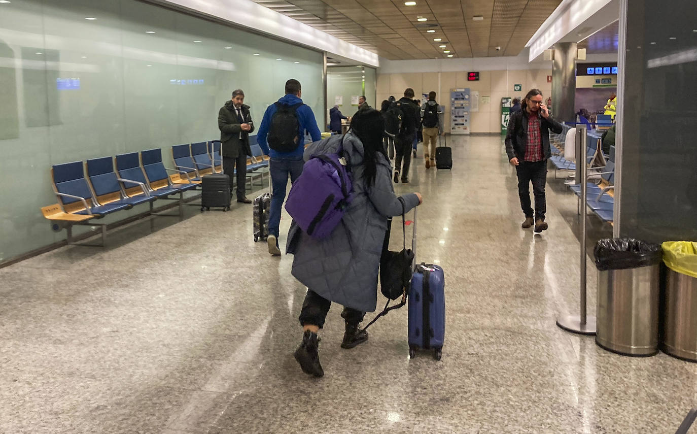 Los pasajeros abandonan la zona de embarque después de anunciarse la cancelación del vuelo de Iberia con destino Madrid