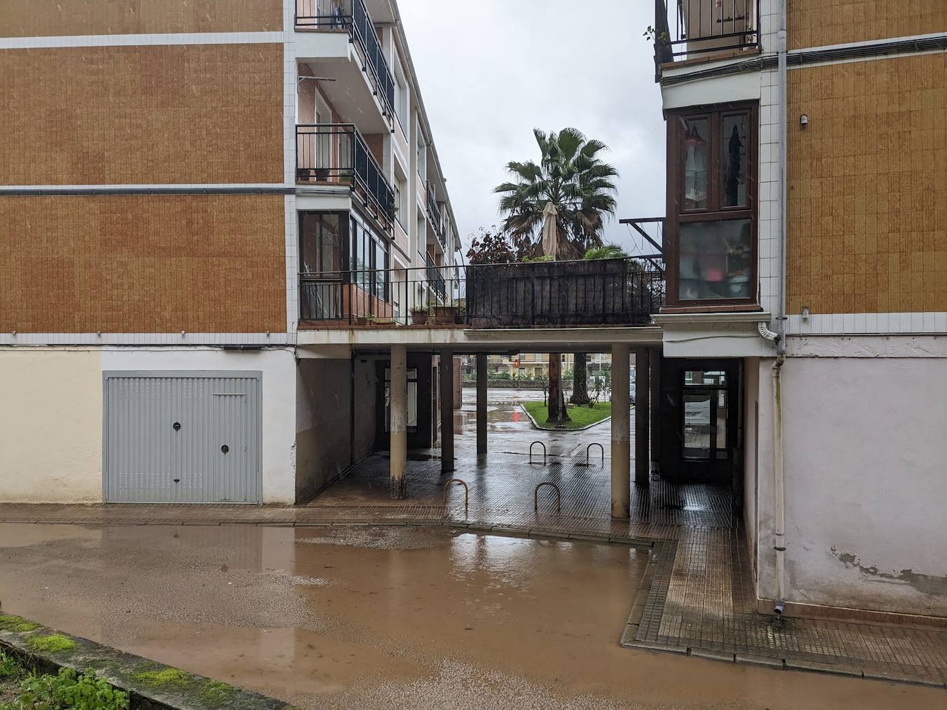 Barrio El Pelegrín (Laredo), totalmente inundado, con operarios acometiendo la limpieza