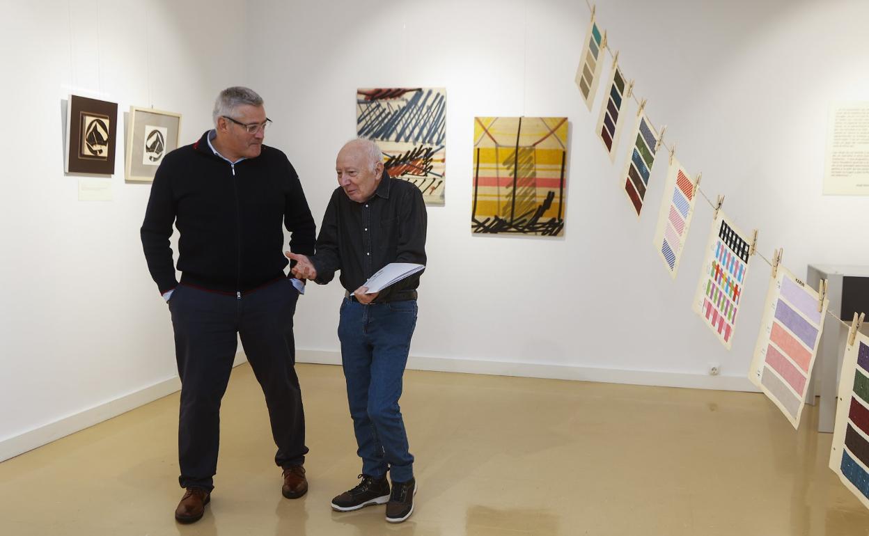 José Noriega explica los contenidos de su exposición a Fernando Zamácola. tVarias personas recorren la muestra tras su inauguración. 