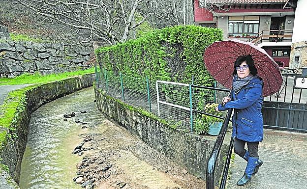 Julia Renedo, de Cabezón de la Sal, en el puente de acceso a su casa, que se inunda cuando llueve.