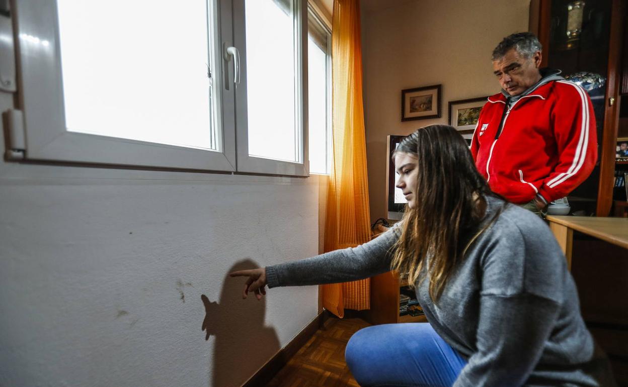 Emilio Diego, residente en Monte, junto a su hija, señala el lugar por el que los ladrones accedieron a su vivienda. 