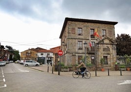 Un vecino atraviesa en bicicleta la plaza del Ayuntamiento.