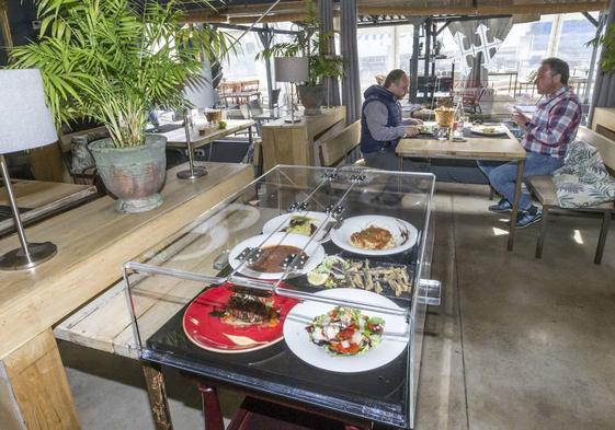 Un expositor muestra a los clientes los platos que integran el menú del día en este restaurante.