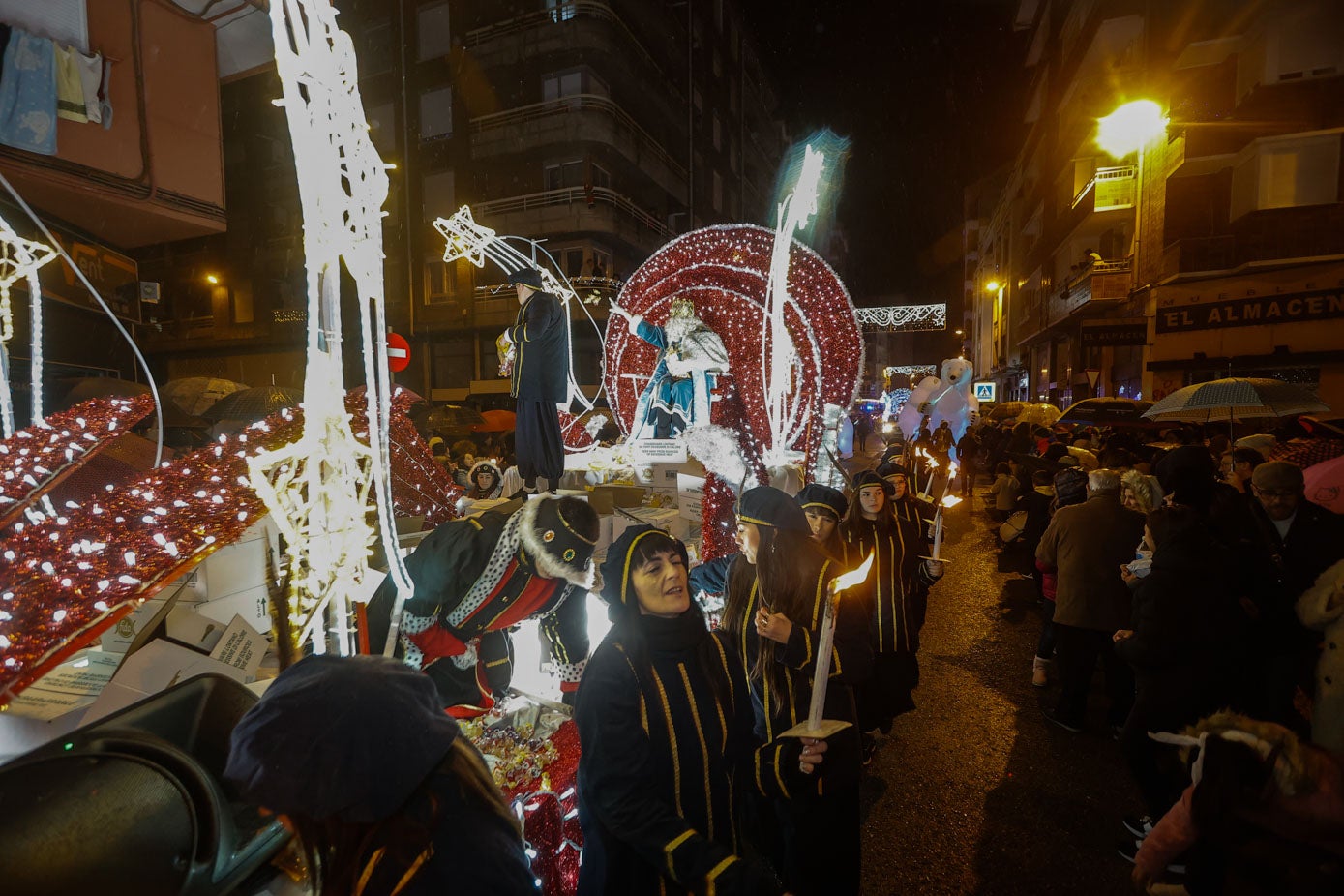 El rey Melchor reparte caramelos desde su carroza.