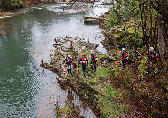 Miembros de Cruz Roja buscan al desaparecido en el río Saja.