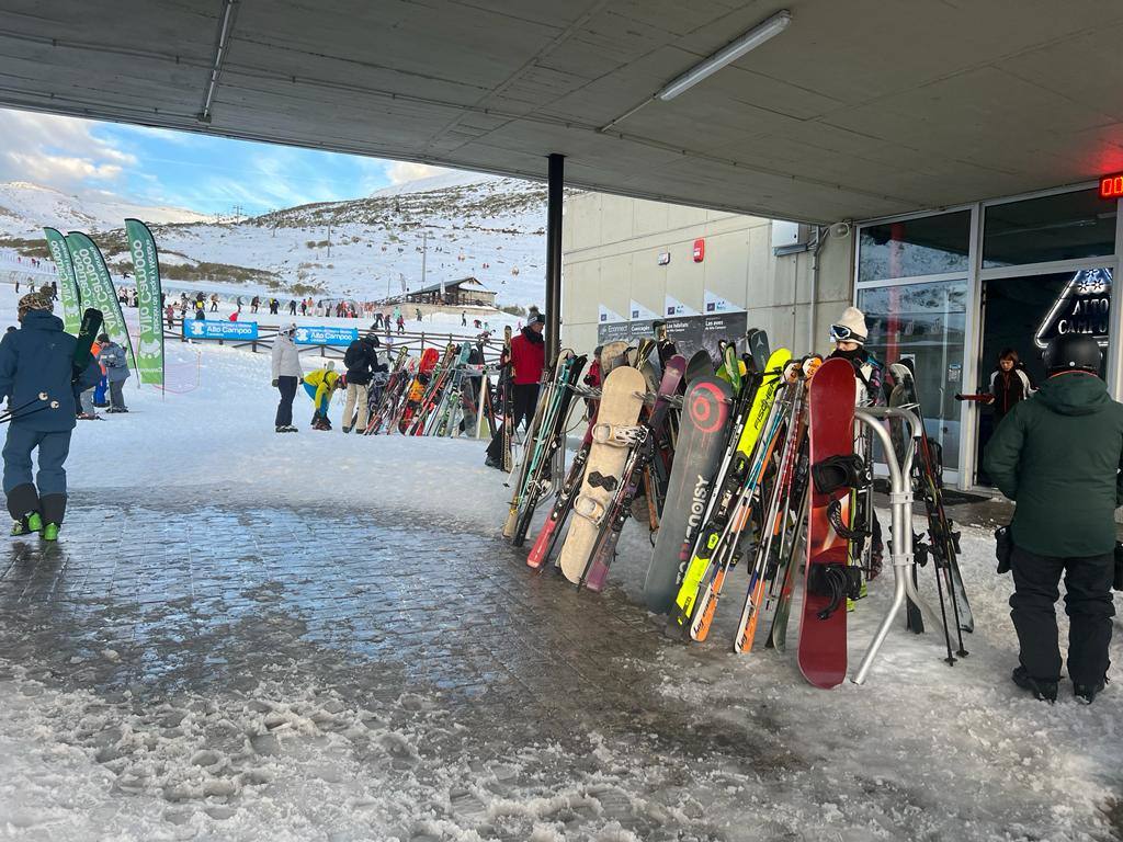 Varias tablas de snow y esquís a pie de pista, junto a la cafetería