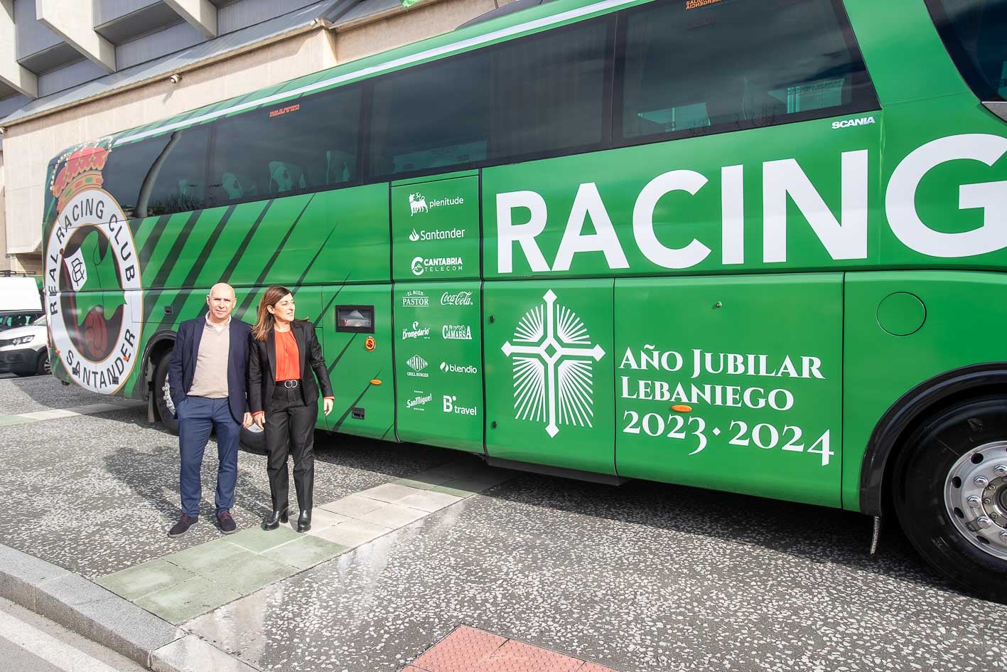 Manolo Higuera y María José Saez de Buruaga ante el autobús del club. 