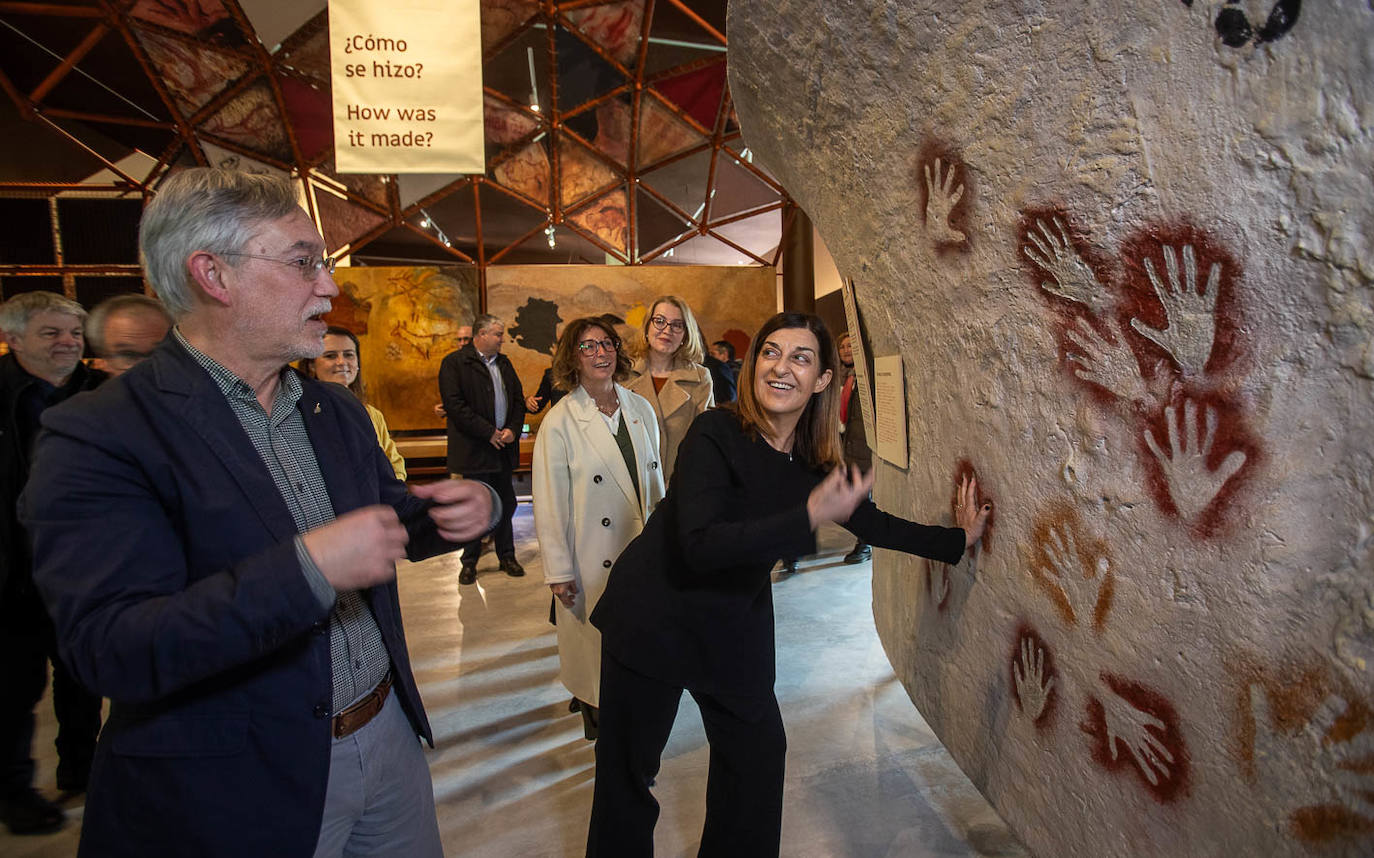 María José Sáenz de Buruaga estampa su mano en la pared de la cueva. 