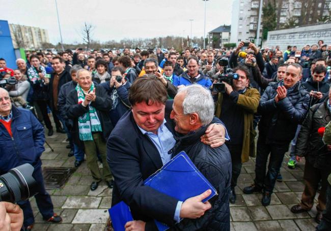 Emoción. Bernardo Colsa, entonces presidente de la Asociación de Peñas, se abraza en el exterior de los Campos de Sport a Tuto Sañudo, recién elegido presidente del Racing, al terminar la Junta General de Accionistas de 2014. Al fondo, la prensa y la multitud de accionistas y masa social que se congregaron aquella mañana en El Sardinero. Se acababa de desalojar a Ángel Lavín y su directiva y el club comenzaba un proceso de reconstrucción que aún no ha concluido.