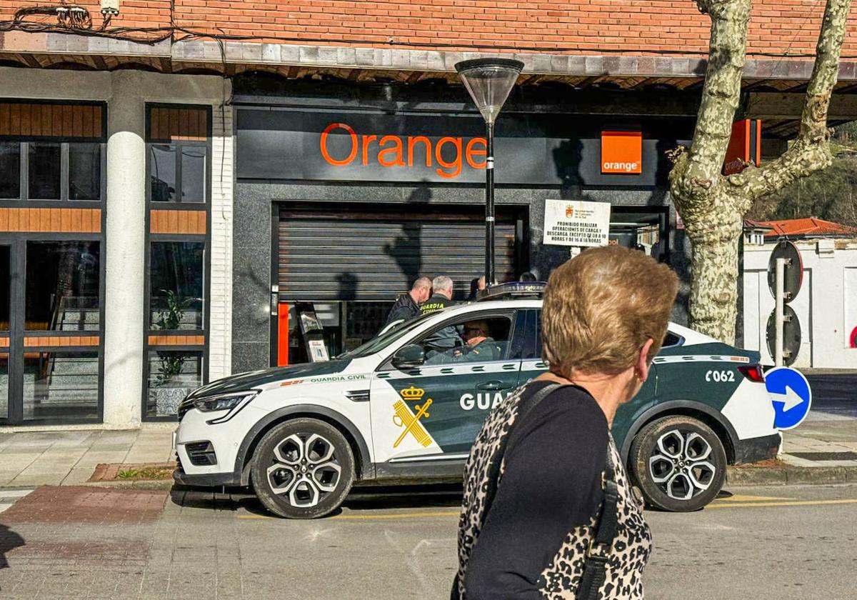 El coche de la Guardia Civil aparcado junto a la tienda de Orange.