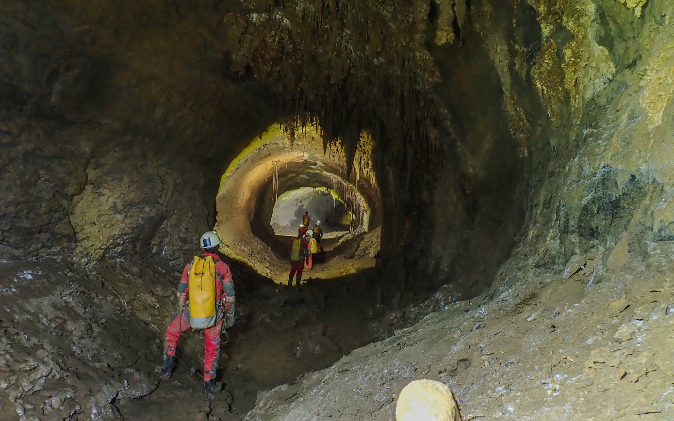 Un grupo de espeleólogos avanza hacia el interior de la cueva más larga de España.