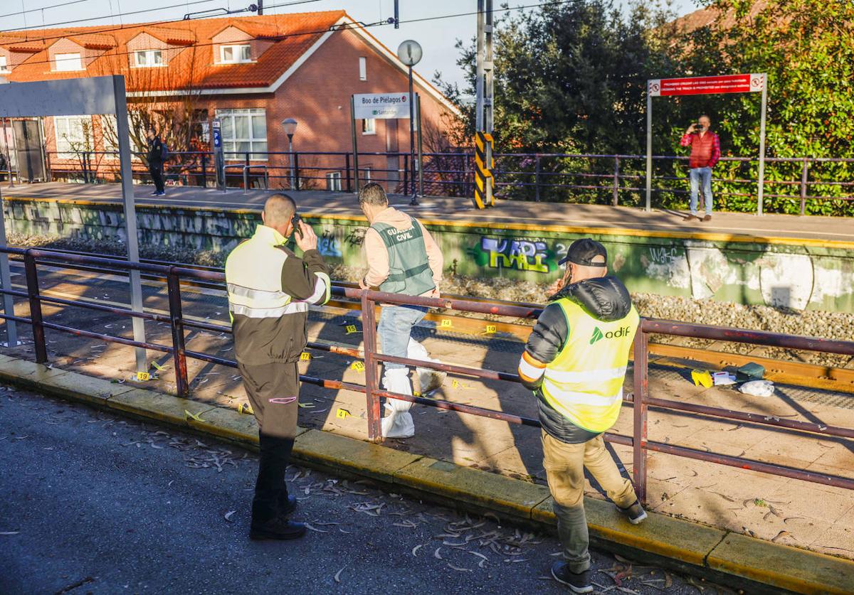 Un agente de la Guardia Civil señala los restos de sangre que dejó la agresión en el apeadero de Boo de Piélagos.