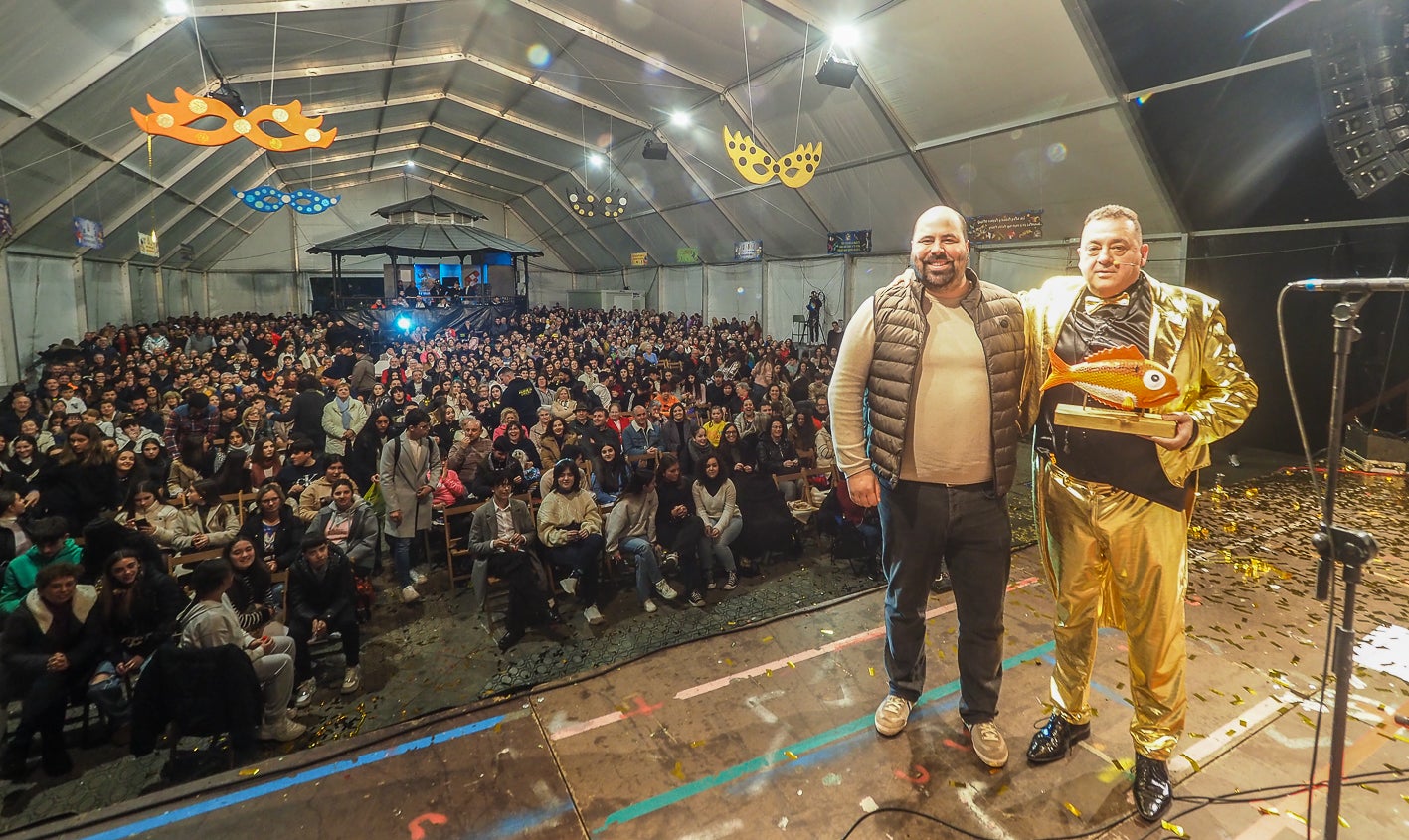 El concejal de Festejos, Alberto Ruigómez, hace entrega al protagonista del  besugo del carnaval, símbolo de la fiesta. 