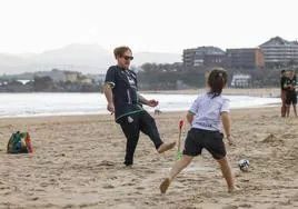 Un hombre y una niña juegan en laplaya de El Sardinero, este jueves.