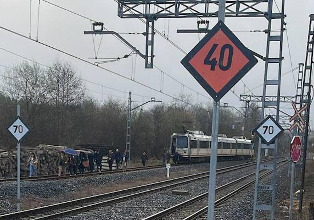 Pasajeros del tren averiado a la altura de Mogro andando por la zona de vías.