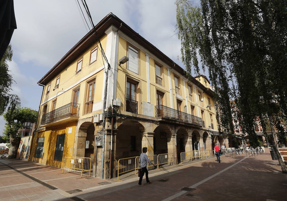 Vecinos caminan junto a los números 4 y 5 del edificio municipal de la plaza Baldomero Iglesias.