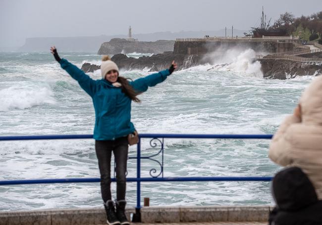 Una joven es retratada con el temporal en el Cantábrico de fondo.