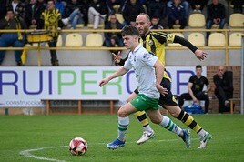 Neco, del Rayo, lleva el balón ante Marcos, del Cayón.