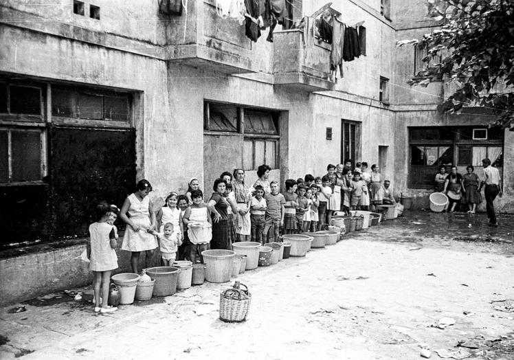 Gentes del barrio en la colas para almacenar el agua.