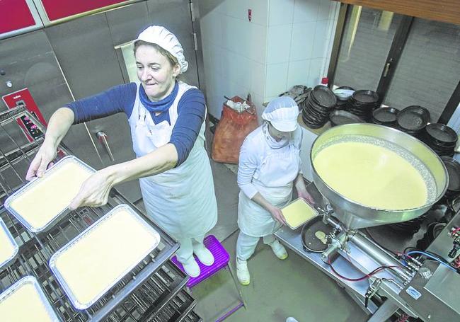 Dos trabajadoras elaboran las quesadas.