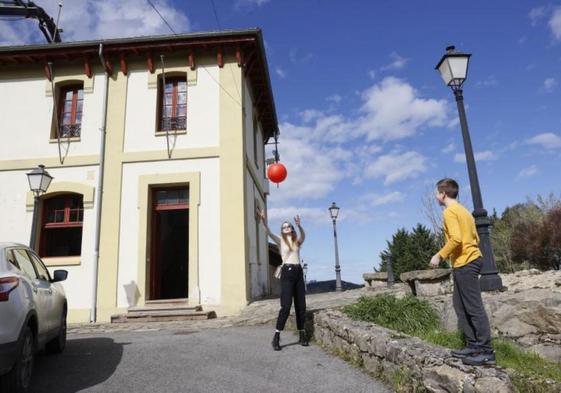 Dos jóvenes juegan a la pelota junto al albergue.