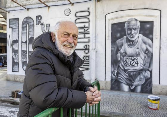 Paco Cobo posa junto al mural realizado por Steve Camino en Laredo.