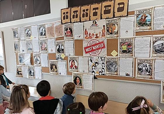 Alumnado del CEIP Costa Quebrada ante un panel con personajes históricos del proyecto 'Time Traveler'.