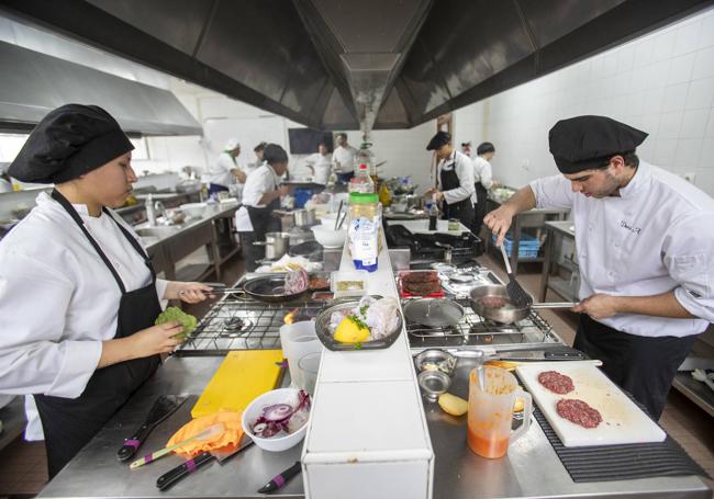 Una vista de la cocina con algunos de los aspirantes preparando sus platos.