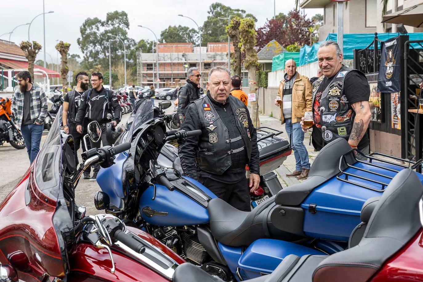 Dos moteros observan una Harley de color azul.