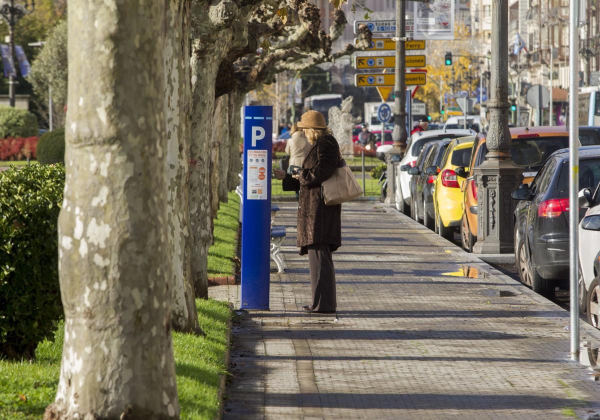 Una mujer paga la OLA en un parquímetro del Paseo de Pereda de Santander.