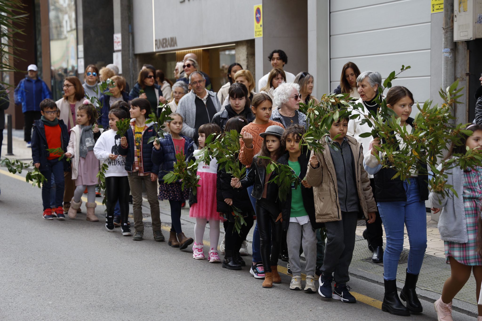 Un grupo de niños porta sus ramos de laurel durante la peregrinación.