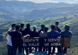 El grupo de vecinos que ha instalado el banco posa con él observando las vistas.