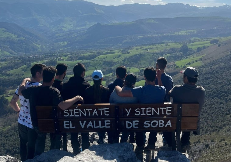 El grupo de vecinos que ha instalado el banco posa con él observando las vistas.