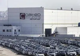 Fábrica de Santander Coated Solutions en el Puerto y, en primer plano llena de coches, la concesión para la potencial ampliación.