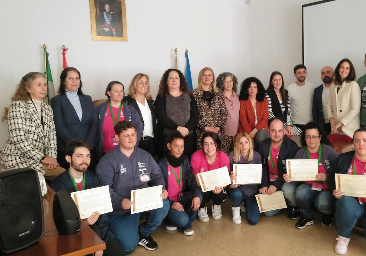 Foto de familia de autoridades locales y alumnos con sus diplomas.