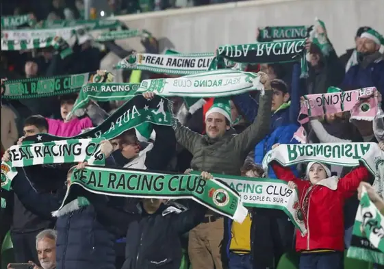 Aficionados del Racing sostienen las bufandas en alto durante un partido en El Sardinero