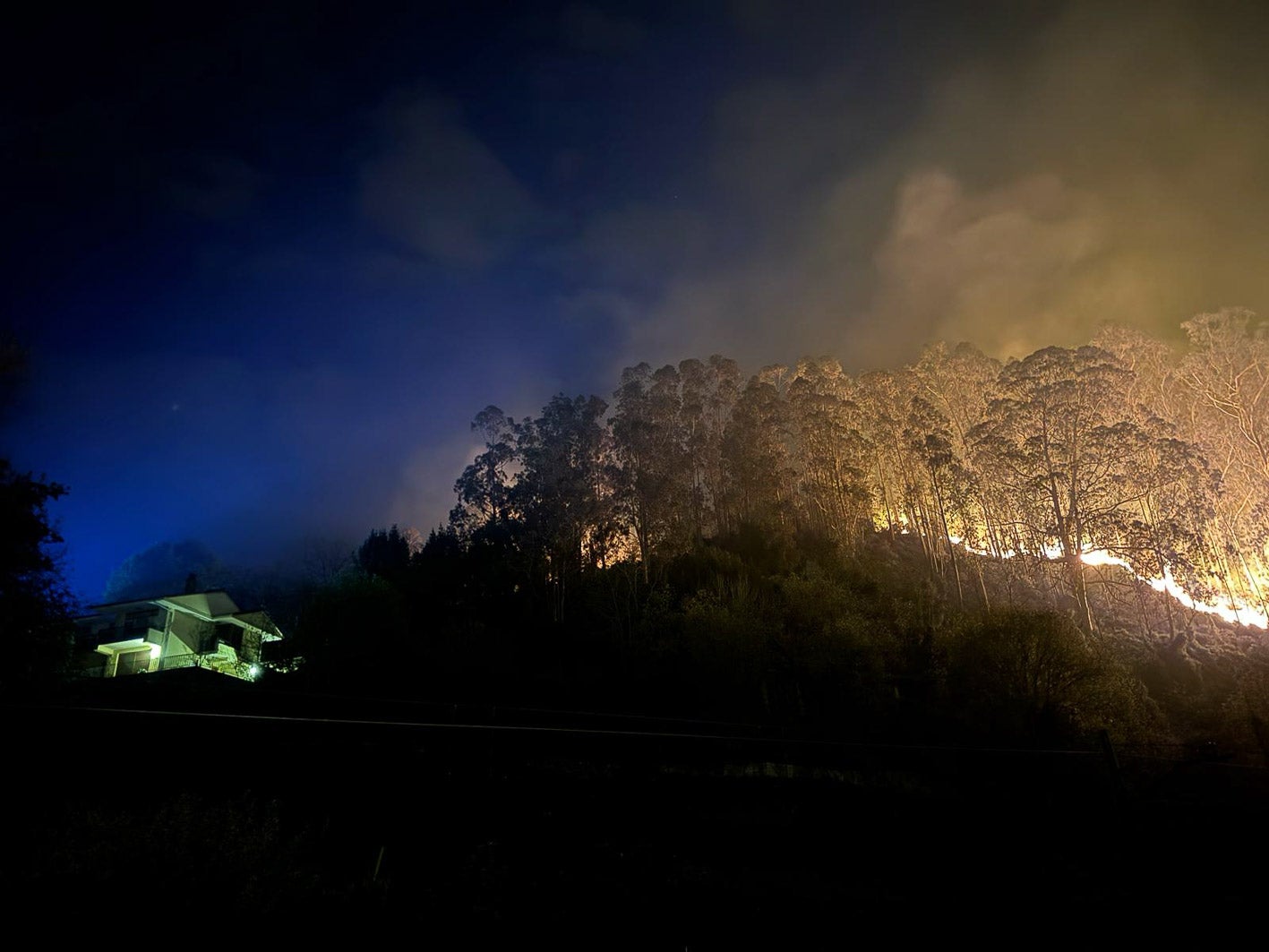 El fuego se aproxima una vivienda en la conocida como zona de Las Nieves, en Casar de Periedo. 