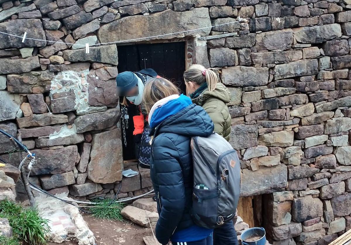 La mujer detenida sale de la cabaña donde hallaron al menor, en presencia de dos agentes de paisano.