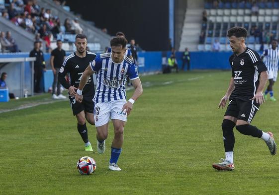 Chus Ruiz controla la pelota ante dos jugadores del Langreo.
