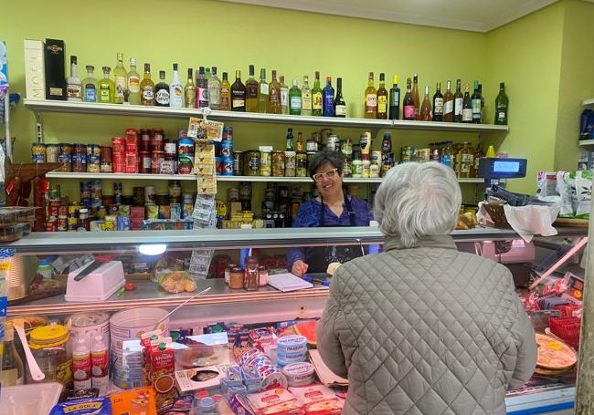 Manuela Mencía atienda a una clienta en su negocio, Alimentación Blanco.