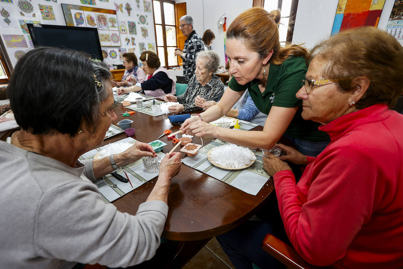 María Loro, coordinadora del Programa Viernes, explica a una usuaria los pasos del proceso de creación de velas en un taller realizado en Villasuso de Cieza.