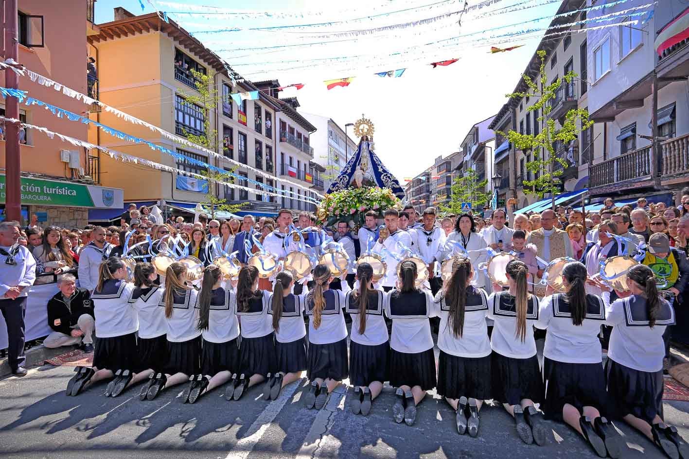 Las picayas arrodilladas cumpliendo la tradición de cantar a la Virgen de la Barquera