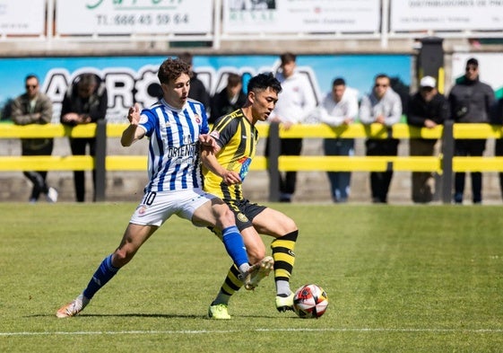 Basurto e Hitoshi disputan un balón en el Fernando Astobiza.